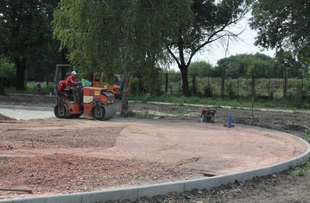 Robotnicy przygotowują nawierzchnię placów zabaw.