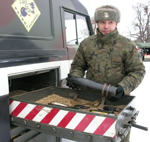 Szeregowy Piotr Bogdan demonstruje pocisk artyleryjski. Patrol saperski jeździ też do szkół, żeby przestrzegać dzieci przed zabawą takimi znaleziskami.