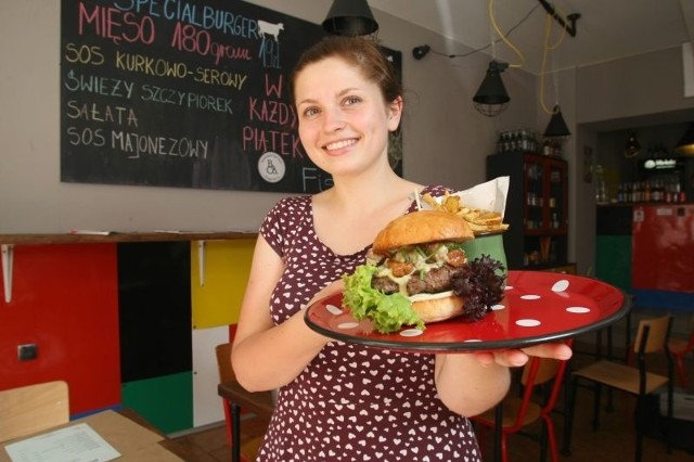 Kamila, kelnerka w Burger&Co w Kielcach prezentuje nowego Specjalburgera z kurkami.