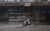 Kraków. Funkcjonariusze policji wodnej chronią most kolejowy przed napływającymi konarami