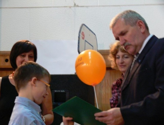 Mistrz ortografii w najmłodszej kategorii wiekowej Łukasz Latkowski, odbiera nagrodę z rąk naczelnika wydziału oświaty Bogusława Uchańskiego.