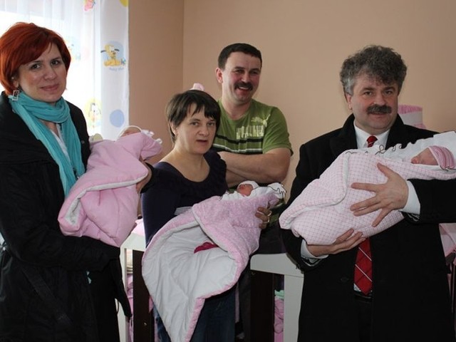 Z lewej Elżbieta Michalska, dyrektor MOPS, z prawej Witold Namyślak, burmistrz Lęborka, wraz z mamą trojaczków trzymają trzy dziewczynki: Jagodę, Martę i Milenę. Z tyłu szczęśliwy ojciec.