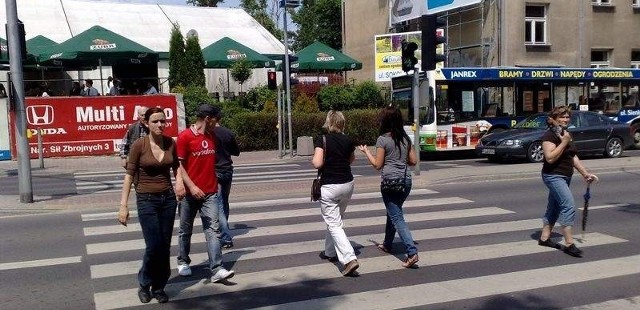 Przechodnie dochodzą do połowy drogi i czekają na wąskiej wysepce na zmianę sygnalizacji. Uważają, że zielone światło świeci się zbyt krótko.