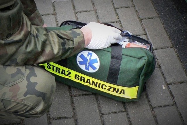 Funkcjonariusze Sekcji Konwojowej Strzeżonego Ośrodka dla Cudzoziemców w Białymstoku udzieli pomocy przedmedycznej kobiecie, która doznała ataku epilepsji.