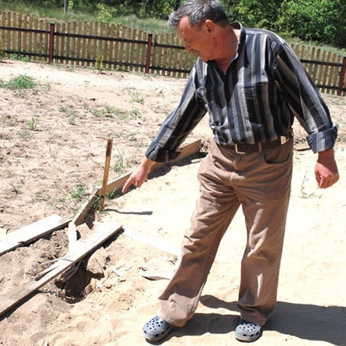 Ryszard Kacała pokazuje miejsce na podwórku, na które we wtorek spadł odłamek pocisku artyleryjskiego.