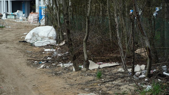 Śmieci obok ogrodzenia działek przy ulicy Łupaszki. Kilkadziesiąt metrów dalej jest budowa. (19.04.2021)