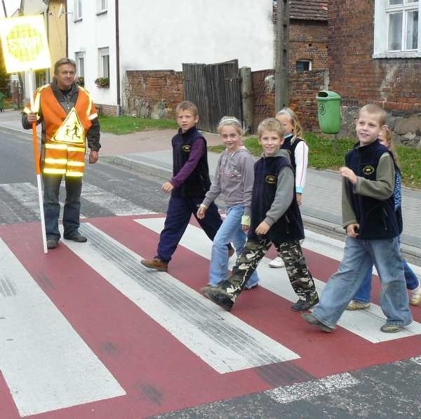 Przed lekcjami dzieci przeprowadza przez powiatową drogę woźny Henryk Misiak