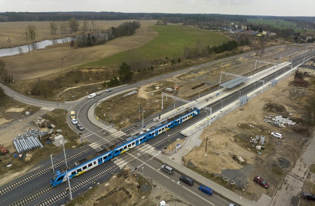 Nowe perony i pociąg pokonujący zmodernizowany przejazd kolejowo-drogowy w Dolicach