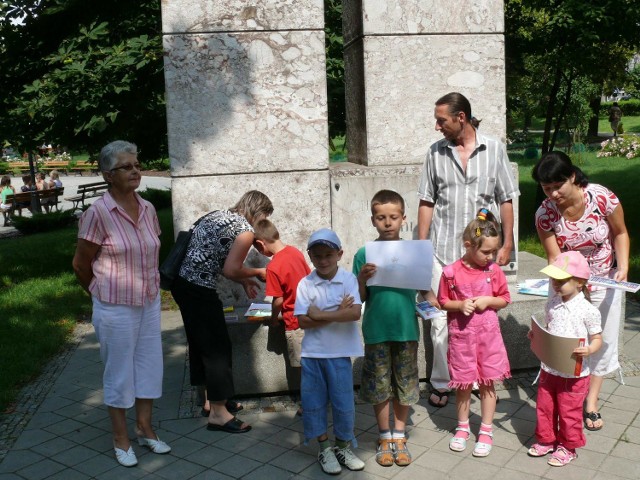 Młodzi uczestnicy pleneru ze swoimi opiekunami oraz instruktorem Pawłem Kisielewskim przy Pomniku Wdzięczności w pińczowskim parku.