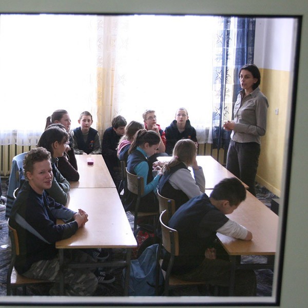 Lekcja biologii w Gimnazjum nr 9 widziana przez oszklone drzwi.