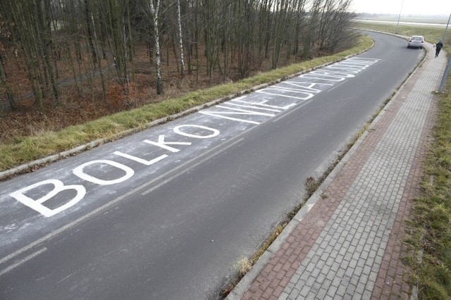 Napis ma kilkanaście metrów długości, a drogowcy, choć uważają, że to wandalizm, nie będą go usuwać. Boją się o stan nawierzchni, którą po próbie usuwanie hasła trzeba by naprawiać.