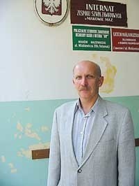 Dyrektor szkoły Ryszard Bednarczyk na tle szyldu, który kilka tygodni temu zawisł pośród innych na internacie