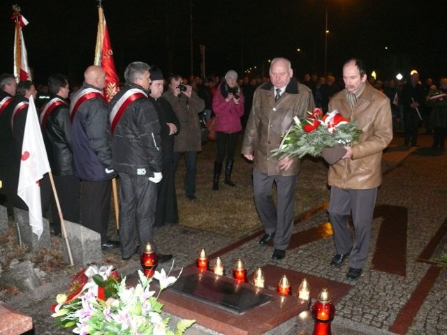 Pod krzyżem kwiaty składają szef hutniczej "S&#8221; Henryk Szostak i regionalnej Andrzej Karczmarek.
