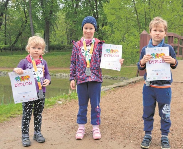 Rodzeństwo Hania, Tosia i Wiktor z dyplomami i medalami za biegi