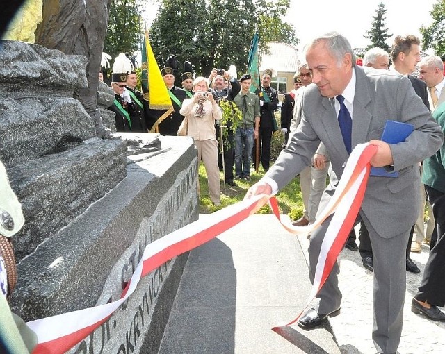 Stefan Struzik, szef miejskich struktur Sojuszu Lewicy Demokratycznej oraz jeden z inicjatorów budowy pomnika, uroczyście zdejmuje wstęgę z cokołu monumentu.