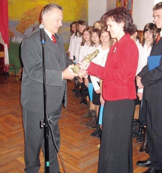 Marian Łuczaj, wiceprzewodniczący sejmiku województwa przekazuje statuetkę dyrektor gimnazjum Katarzynie Wróbel