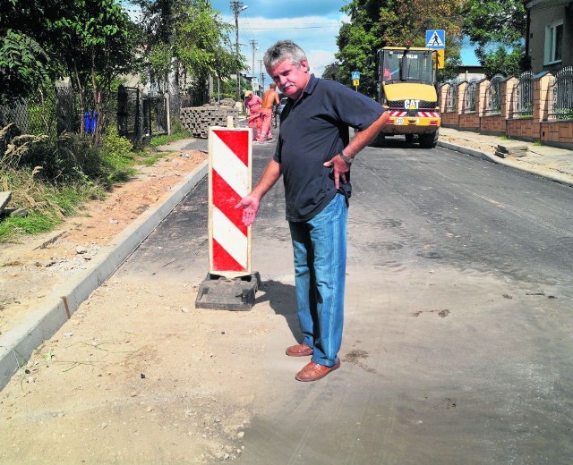 Wojciech Leki pokazuje miejsce, gdzie ekipa budowlana skuła świeżo położony asfalt na Cegielnianej