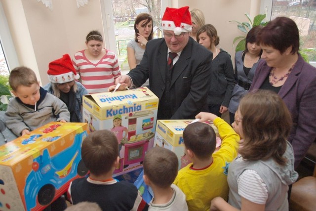 Rektor Wyższej Szkoły Ekonomicznej Janusz Bek rozdaje prezenty.