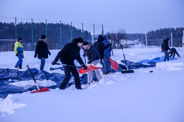Kibice Arki Gdynia chwycili za łopaty, inny sprzęt i zabrali się dziś za odśnieżanie trawiastego boiska w Chwaszczynie.