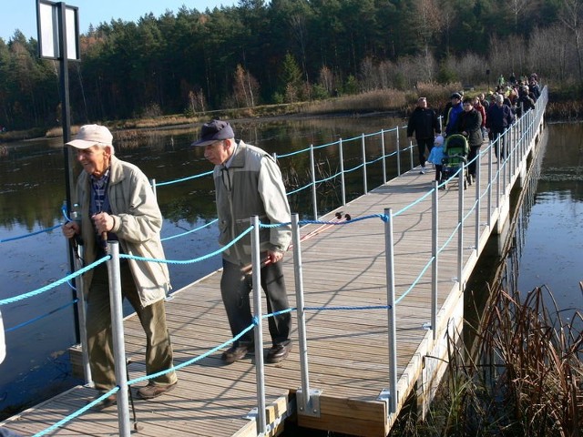 Uczestnicy powiatowego marszobiegu przekraczają most pontonowy na zalewie w Mostkach.