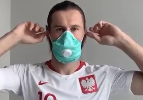 Grzegorz Krychowiak, piłkarski reprezentant Polski. w ochronnej maseczce.