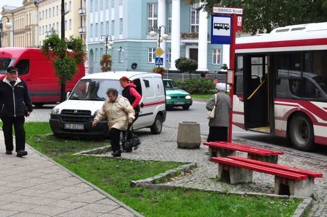 Ludzie muszą pokonywać trawnik, żeby dostać się na chodnik lub do autobusu.