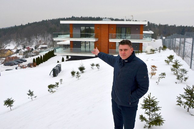 Dominik Jaroszek, menadżer do spraw klientów w firmie Solaris Oze z Kielc, przed budynkiem hotelu Odyssey w Dąbrowie, na którego dachu zamontowano 148 paneli fotowoltaicznych.