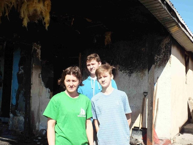 Drewniana część domu i jego wnętrze spłonęły doszczętnie. Rodzina Milewskich na tle pogorzeliska.