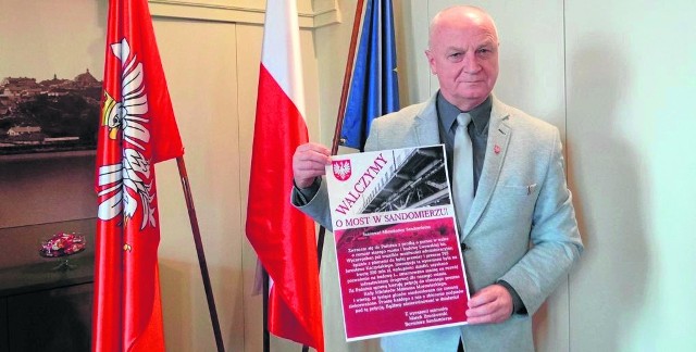 Burmistrz Sandomierza Marek Bronkowski pokazuje plakat informacyjny o akcji "Walczymy o most w Sandomierzu". Burmistrz zadeklarował, że także przyłącza się do zbierania podpisów.