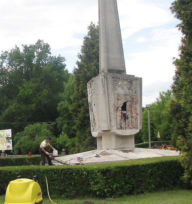 Mirosław Michalski przy pracach usuwających niepotrzebne napisy na pomniku.