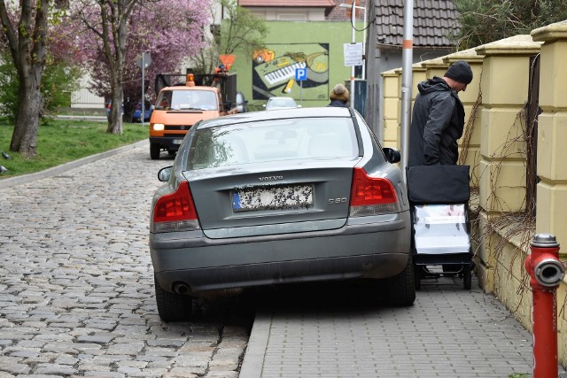 Ten mistrz zaparkował tak, że pieszemu nie pozostaje nic innego, jak przeciskać się pomiędzy autem a płotem, albo wyjść na jezdnię.