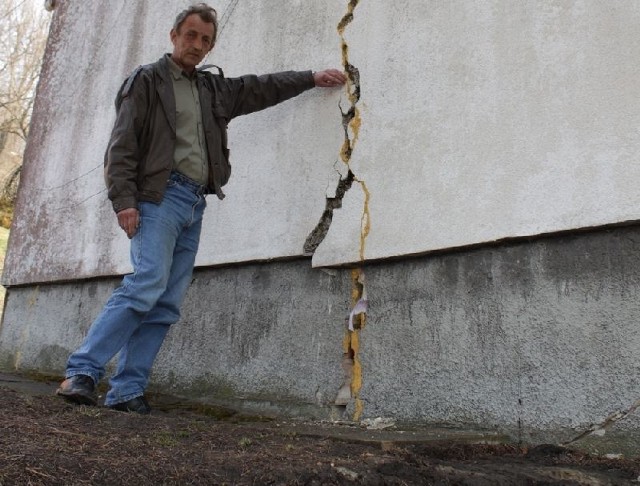 Władysław Gajda z Krzeszowa pokazuje ogromne pęknięcie na ścianie domu, w którym mieszkał z rodziną.