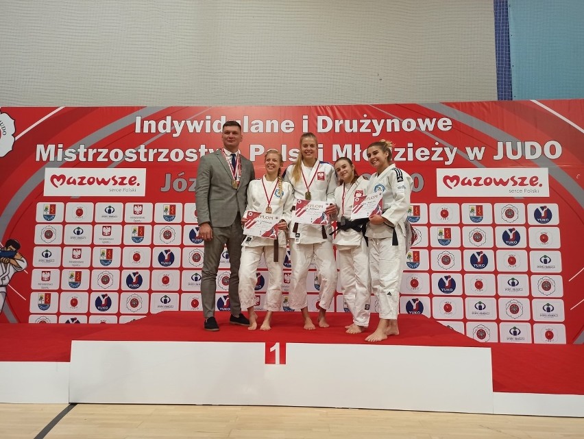 Trener Radosław Miśkiewicz ze swoimi zawodniczkami na podium...