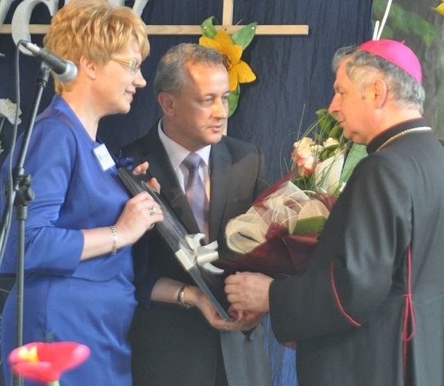 Dyrektor Jan Słuszniak i jego zastępczyni Elżbieta Kwapis wręczają statuetkę "Przyjaciel ośrodka" księdzu biskupowi Henrykowi Tomasikowi