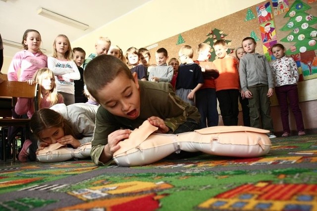 Robimy dwa wdechy i trzydzieści uciśnięć &#8211; pokazuje Bartek Rożko z II b. Razem z Weroniką Czerniawską ćwiczą reanimację na treningowych fantomach.