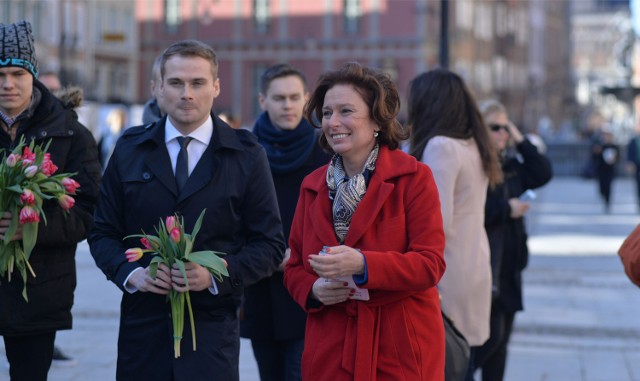 Małgorzata Kidawa-Błońska rozdaje paniom  kwiaty na Dzień Kobiet