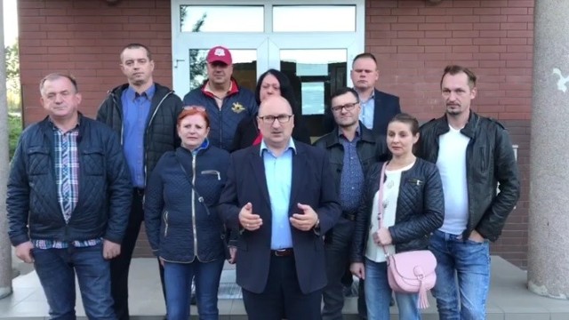 Robert Stępień i jego kandydaci na radnych przed budynkiem Szkoły Podstawowej w Sławsku