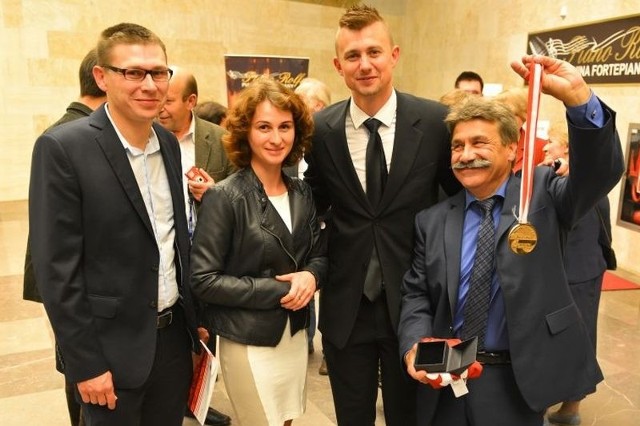Szczęśliwy, nowy posiadacz złotego medalu MP siatkarzy 2012/2013 z rodziną i Krzysztofem Ignaczakiem, mistrzem ceremonii licytacji tego trofeum.