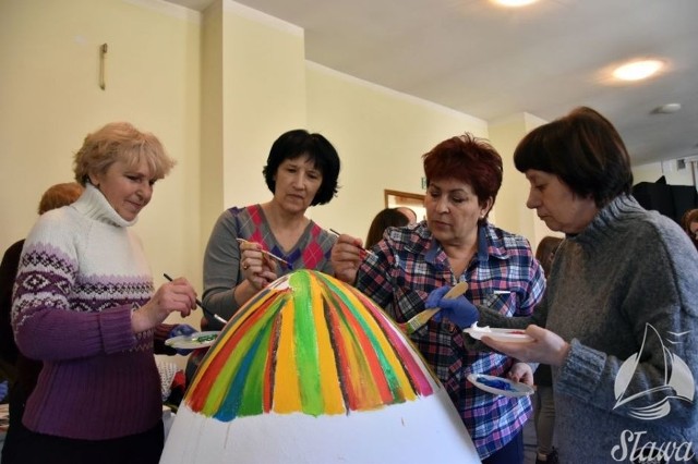 W sławskim Domu Kultury odbyła się  druga edycja przedświątecznego malowania pisanek. Panie ze słąwskiego stowarzyszenia kobiet akwtynych usmażyły jajecznicę z dwustu jaj.W sali kameralnej domu kultury ozdabiane były trzy ogromne styropianowe pisanki. Dla młodzieży były też przygotowane warsztaty decoupage pod kierunkiem Marty Tomczak, która prowadzi zespół im. Michała Krechowca.Wielkie pisanki malowały trzy zespoły, jedną na ludowo stroiła Akademia Dorosłego Człowieka, druga pisanka powstawała przy udziale uczniów Niepublicznej Szkoły Podstawowej Happy House w Sławie. Ostatnią patriotyczną, nawiązującą do Jubileuszu 100-lecia odzyskania Niepodległości przez Polskę szykował zespół z urzędu miejskiego, którym dowodził zastępca burmistrza Krzysztof Gruszewski. Po wspólnym malowaniu dla wszystkich uczestników panie ze Stowarzyszenia Aktywnych Kobiet w gminie Sława zaserwowały jajecznicę z blisko 200 jaj. Wielkie pisanki przygotowane podczas poniedziałkowego spotkania, a także te z roku ubiegłego wkrótce będzie można zobaczyć na Nowym Rynku w Sławie.Zobacz też: 18 karatowe złote zajączki i Jackson Pollock na pisance. Szalone pomysły czekoladników przed Wielkanocąźródło: Associated PressPOLECAMY PAŃSTWA UWADZE: