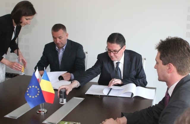 Michał Solowow i Gheorghe Predescu podpisują protokół w obecnosci marszałka województwa Adama Jarubasa