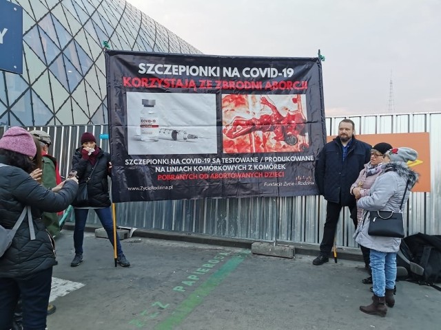 Przeciwnicy szczepień ustawili się z transparentem przed głównym wejściem na dworzec kolejowy w Poznaniu