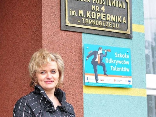 Edyta Sztylko, pełniąca obowiązki dyrektor Szkoły Podstawowej numer 4 w Tarnobrzegu prezentuje tablicę "Szkoła Odkrywców Talentów&#8221;.