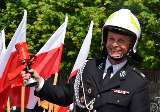 Prezes Ochotniczej Straży Pożarnej w Rudzie Malenieckiej Gerard Pachuc z prezentami od przyjaciół - hełmem strażackim i prądownicą