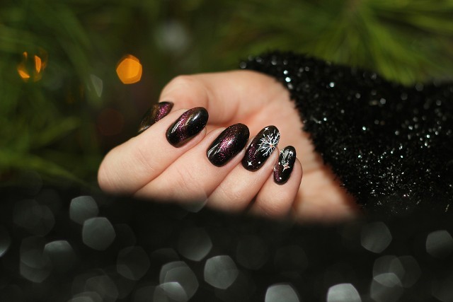 Śliwkowy manicure jest idealny na chłodną świąteczną aurę. Delikatnie ozdobiony motywem świątecznym dobrze komponuje się z wieczorową kreacją.