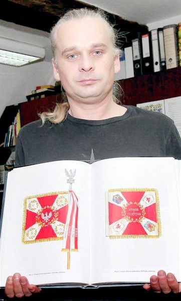Zdjęcie sztandaru 18 Pułku Ułanów Pomorskich prezentuje Mariusz Żebrowski, pracownik muzeum