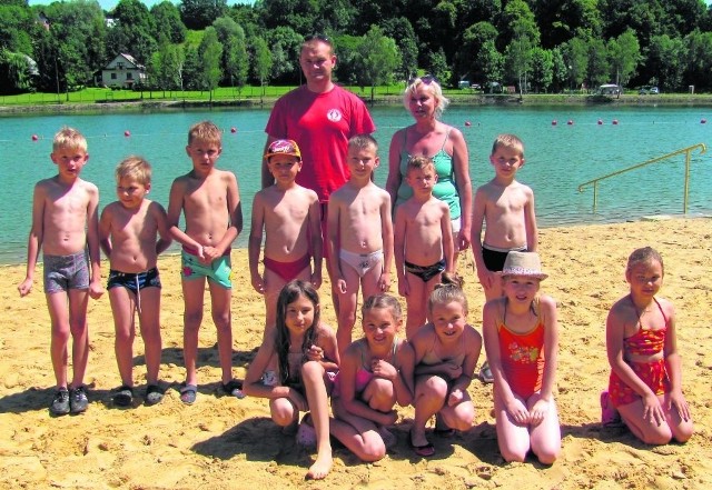 Grupa dzieci z Łapanowa uczestniczących w nauce pływania organizowanej na tamtejszym zalewie