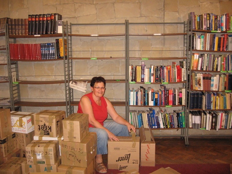 W czytelni zastajemy Marię Karkowską, która zabiera książki...