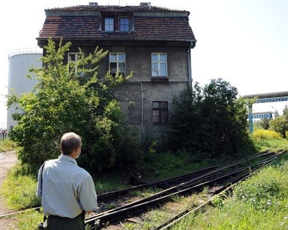 Budynek przy ul. Górnośląskiej. Otoczony jest z obu stron torami kolejowymi, drogą transportową dla chemikaliów z portu, wielkimi silosami do mas bitumicznych, a do tego cały parter zajmuje trafostacja.