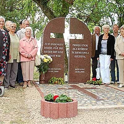 Byli i obecni mieszkańcy Różanek stoją przy ufundowanym przez siebie pomniku. Stanął on w tym miejscu już dwa lata temu, ale teraz zostało ukończone jego otoczenie.