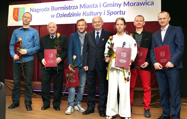 Najmłodsza nagrodzona w obszarze sportu Oliwia Skiba z Klubu Karate Morawica z pozostałymi wyróżnionymi i burmistrzem.